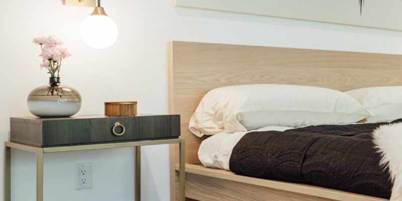Minimalist modern farmhouse bedroom with natural woods and gold accents.
