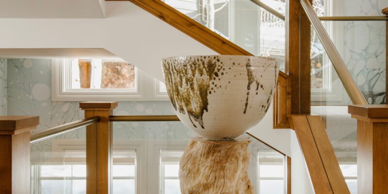 Beautiful wood stairwell in a Salt Lake City luxury home surrounded by tall windows.