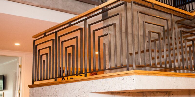 Custom Utah stairwell with unique geometrical steel beams and warm wood banisters.