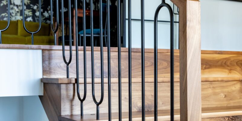 Custom steel banister in a matte black finish with warm wood integrated throughout.